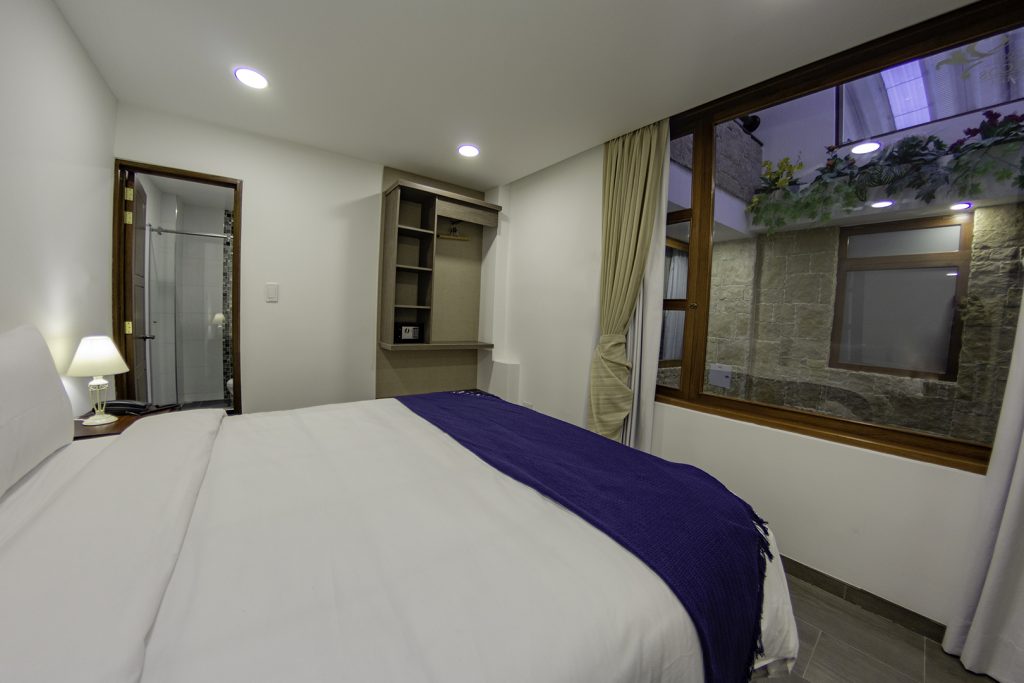 Cama queen y armario del Hotel Boutique San Chiquinquirá